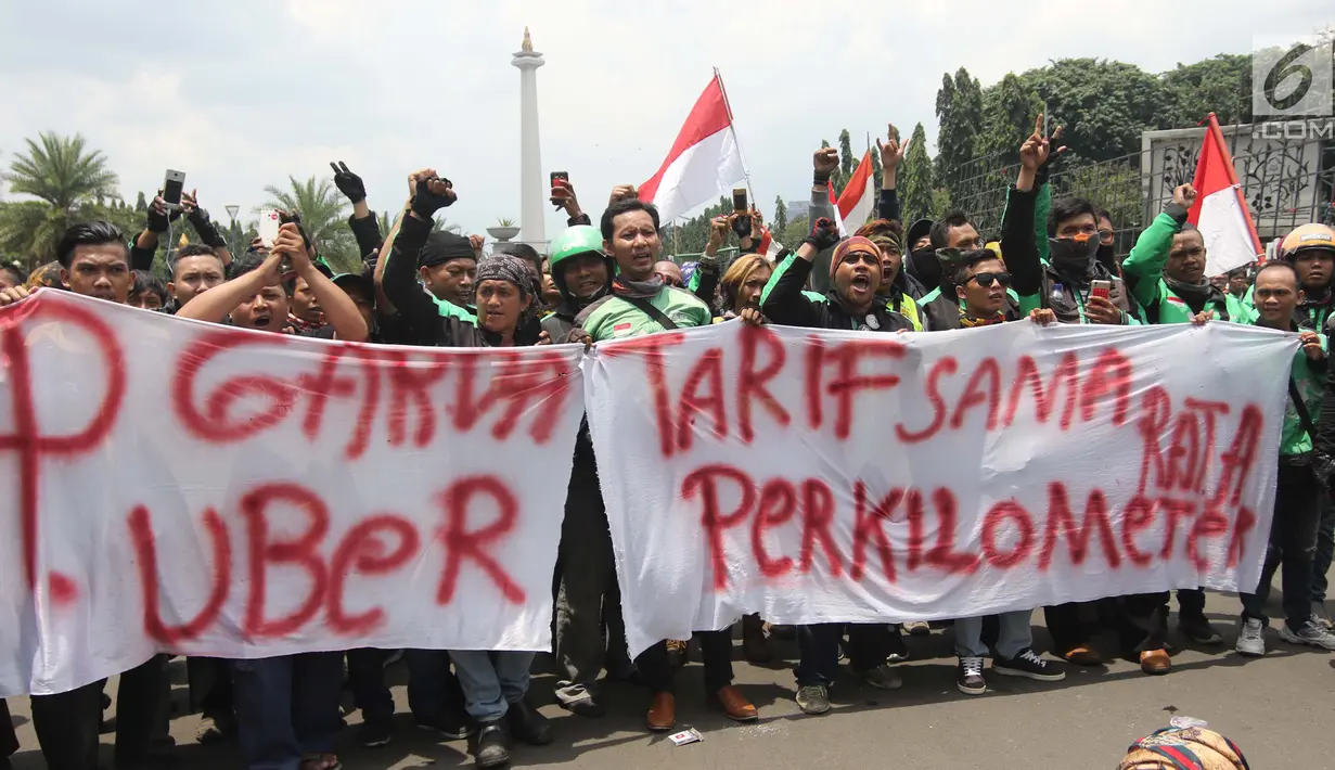 Sejumlah pengemudi ojek online membentangkan spanduk saat menggelar aksi di seberang Istana Merdeka, Jakarta, Selasa (27/3). Mereka juga meminta legalitas angkutan ojek online. (Liputan6.com/Arya Manggala)