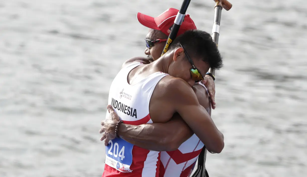 Pasangan Indonesia, Anwar Tara dan Yuda Firmansyah, selebrasi usai menjadi yang tercepat pada SEA Games 2019 cabang kano nomor 1000 meter putra di Subic, Filipina, Jumat (6/12). Pasangan Indonesia berhasil meraih medali emas. (Bola.com/M iqbal Ichsan)