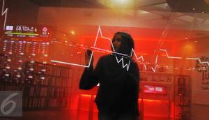 Pengunjung tengah melintasi layar pergerakan saham di BEI, Jakarta, Senin (13/2). Pembukaan perdagangan bursa hari ini, Indeks Harga Saham Gabungan (IHSG) tercatat menguat 0,57% atau 30,45 poin ke level 5.402,44. (Liputan6.com/Angga Yuniar)