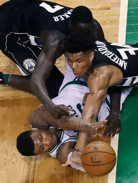 Pemain Boston Celtics, Marcus Smart (bawah) berebut bola dengan dua pemain Milwaukee Bucks pada laga playoffs NBA basketball di TD Garden, Boston, (24/4/2018). Celtics menang  92-87. (AP/Charles Krupa)