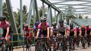 Aksi para pebalap sepeda saat melewati sebuah jembatan di Etape 1 Tour de Singkarak 2015, Sabtu (3/10/2015). (Bola.com/Arief Bagus)