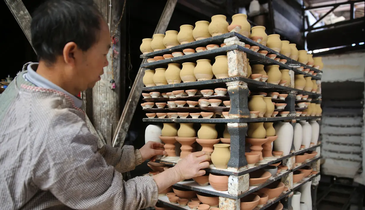 Seorang perajin bekerja di bengkel pembuatan tembikar di Desa Wanyao, Mazhan, Tengchong, Provinsi Yunnan, China, 18 November 2020. Wanyao merupakan sebuah desa yang memiliki spesialiasi dalam pembuatan tembikar. (Xinhua/Liang Zhiqiang)