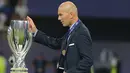 Pelatih Real Madrid Zinedine Zidane menyentuh trofi saat pertandingan sepak bola final Piala Super Eropa antara Real Madrid dan MU di Philip II Arena di Skopje, (8/8). Real Madrid mengalahkan Manchester United 2-1. (AP Photo/Boris Grdanoski)