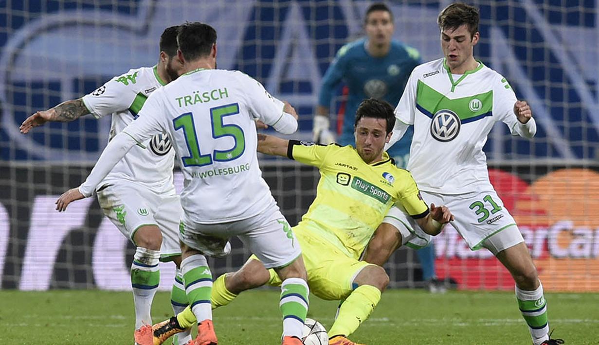 Gelandang Gent, Brecgt Dejaegere, kesulitan lolos karena diapit para pemain Wolfsburg. Dua gol Gent baru bisa tercipta pada menit ke 80 dan 89. (AFP/John Thys)