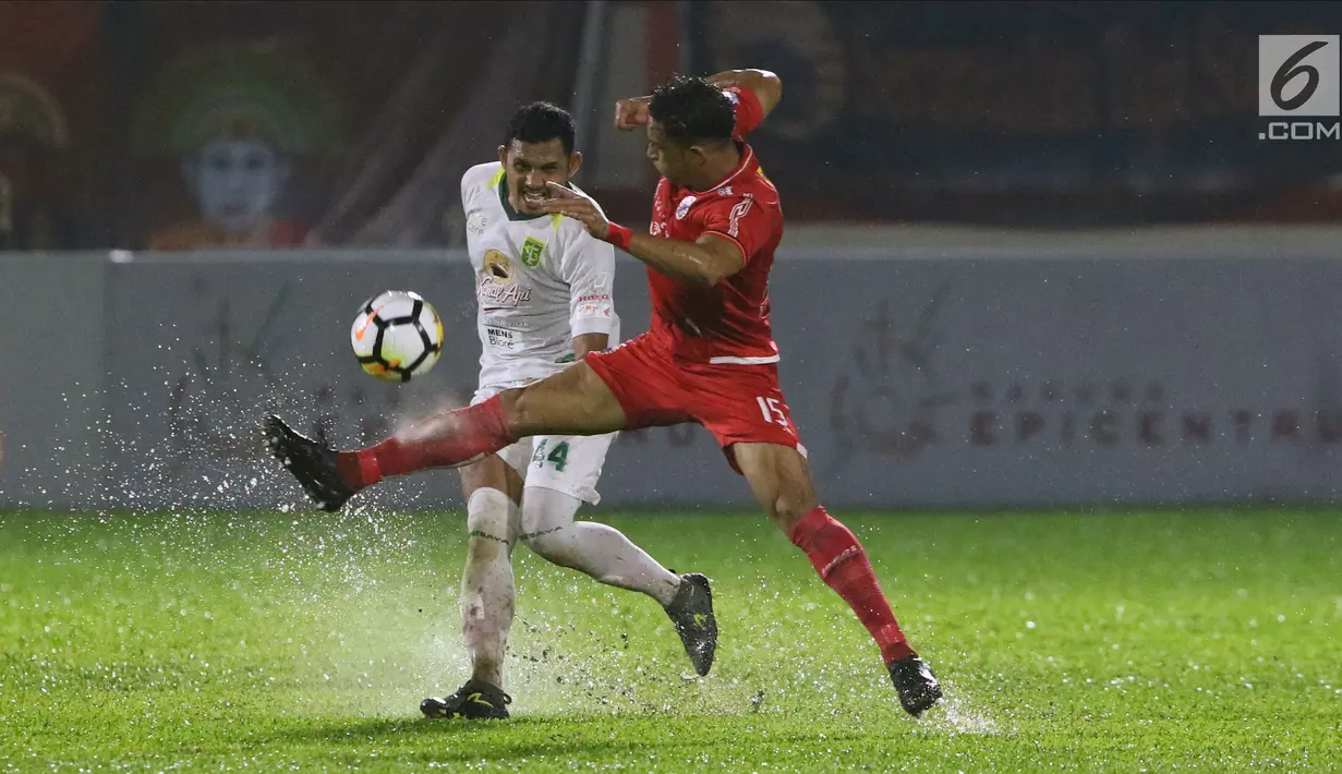 Bek Persebaya, Andri Muladi berebut bola dengan pemain Persija, Addison Alves pada lanjutan Go-Jek Liga 1 Indonesia 2018 bersama Bukalapak di Lapangan PTIK, Jakarta, Selasa (26/6). Babak pertama Persija tertinggal 0-1. (Liputan6.com/Helmi Fithriansyah)