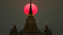 Matahari terbenam di belakang Kuil Wat Saket, atau Gunung Emas di Bangkok, Thailand (11/3). (Reuters/Athit Perawongmetha)