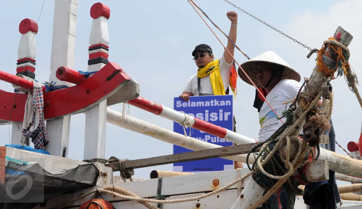 Sejumlah nelayan bersama aktivis Walhi menunjukkan poster berisi penolakan terhadap proyek reklamasi Teluk Jakarta saat upacara sedekah bumi yang lebih dikenal dengan sebutan Nadran di Muara Angke, Jakarta, Minggu (13/12/2015). (Liputan6.com/Helmi Afandi)