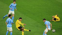 Gelandang Borussia Dortmund, Jude Bellingham (tengah) melepaskan tendangan yang berbuah gol ke gawang Manchester City dalam laga leg kedua perempatfinal Liga Champions 2020/2021 di Signal Iduna Park, Dortmund, Rabu (14/4/2021). Dortmund kalah 1-2 dari Manchester City. (AFP/Wolfgang Rattay/Pool)
