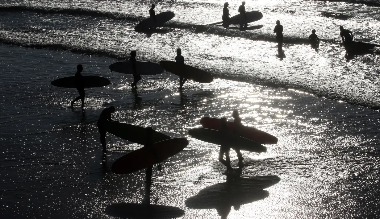 Peselancar di Samudra Atlantik di Biarritz, Prancis barat daya, Rabu (27/10/2021). Suhu di Prancis barat daya mencapai 20 derajat Celcius (68 Fahrenheit). (AP Photo/Bob Edme)