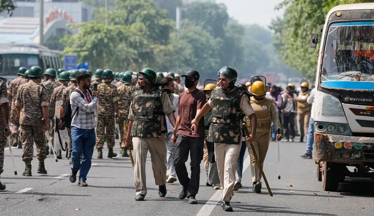 Petugas kepolisian menahan sejumlah demonstran saat aksi unjuk rasa kaum muda yang menuntut pengunduran diri Ketua Komisi Pemilihan Umum India, Gyanesh Kumar, di New Delhi, India, Sabtu (10/10/2026). (AP Photo/Manish Swarup)