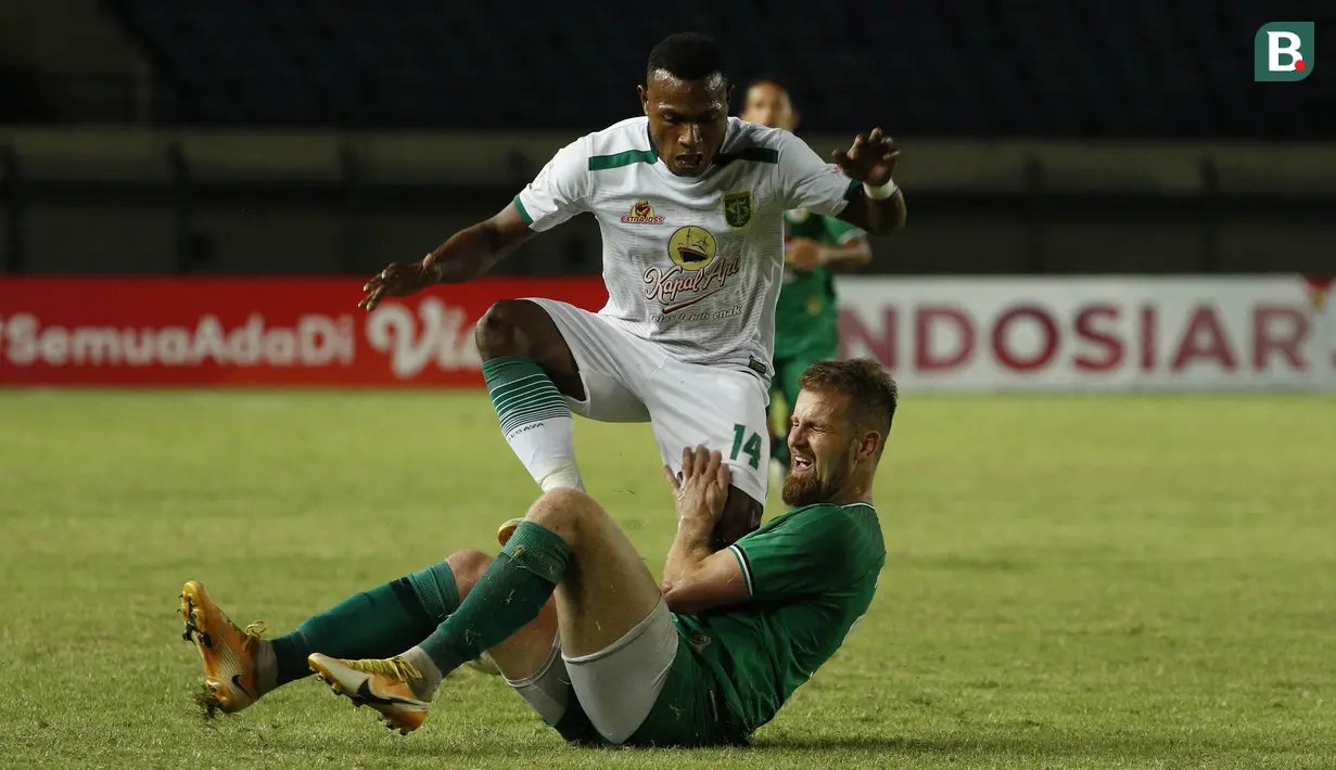 Gelandang Persebaya Surabaya, Franc Rikhart Sokoy (tengah atas) berusaha melewati hadangan gelandang PS Sleman, Maslac Mario (bawah) dalam laga Grup C Piala Menpora 2021 di Stadion Si Jalak Harupat, Bandung, Rabu (7/4/2021). Persebaya kalah 0-1 dari PS Sleman. (Bola.com/Ikhwan Yanuar)