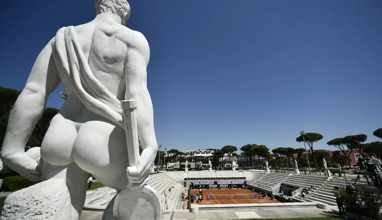 Pemandangan umum memperlihatkan patung dan lapangan tenis pada putaran pertama turnamen tenis Italia Terbuka di Foro Italico, Roma, Selasa (10/5/2021). Pertandingan tersebut dimainkan tanpa penonto karena pembatasan COVID-19. (Filippo MONTEFORTE / AFP)