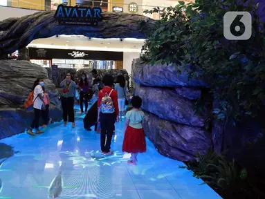 Pengunjung menjelajahi dunia pandora ala Avatar di Senayan City, Jakarta, Senin (14/12/2022). Senayan City menghadirkan Festive Season – The Festive Mood mulai tanggal 12 Desember – 8 Januari 2023, salah satunya Avatar Pandora Experience. (Liputan6.com/Herman Zakharia)