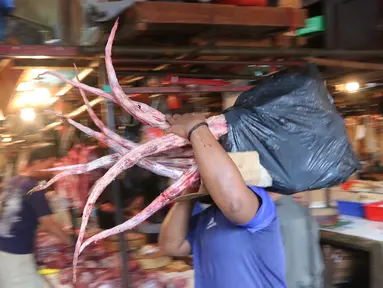 Pedagang membawa buntut sapi di Pasar Senen, Jakarta, Jumat (5/8). Pemerintah mencabut ketentuan kewajiban importir daging untuk menyerap daging lokal sebanyak tiga persen dari total kuota impor yang diperoleh. (Liputan6.com/Angga Yuniar)