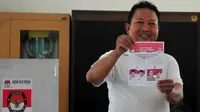 Warga menunjukan kertas suara sebelum melakukan pencoblosan ulang di TPS 03 Kelurahan Bendungan Hilir, Jakarta, Sabtu (19/7/14). (Liputan6.com/Johan Tallo) 