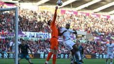 Kiper Southampton, Alex McCarthy menghalau bola dari kejaran pemain Swansea, Andre Ayew pada lanjutan Premier League di Liberty Stadium, Swansea, (8/5/2018). Swasea City kalah dari Soton 0-1. (AFP/Geoff Caddick)