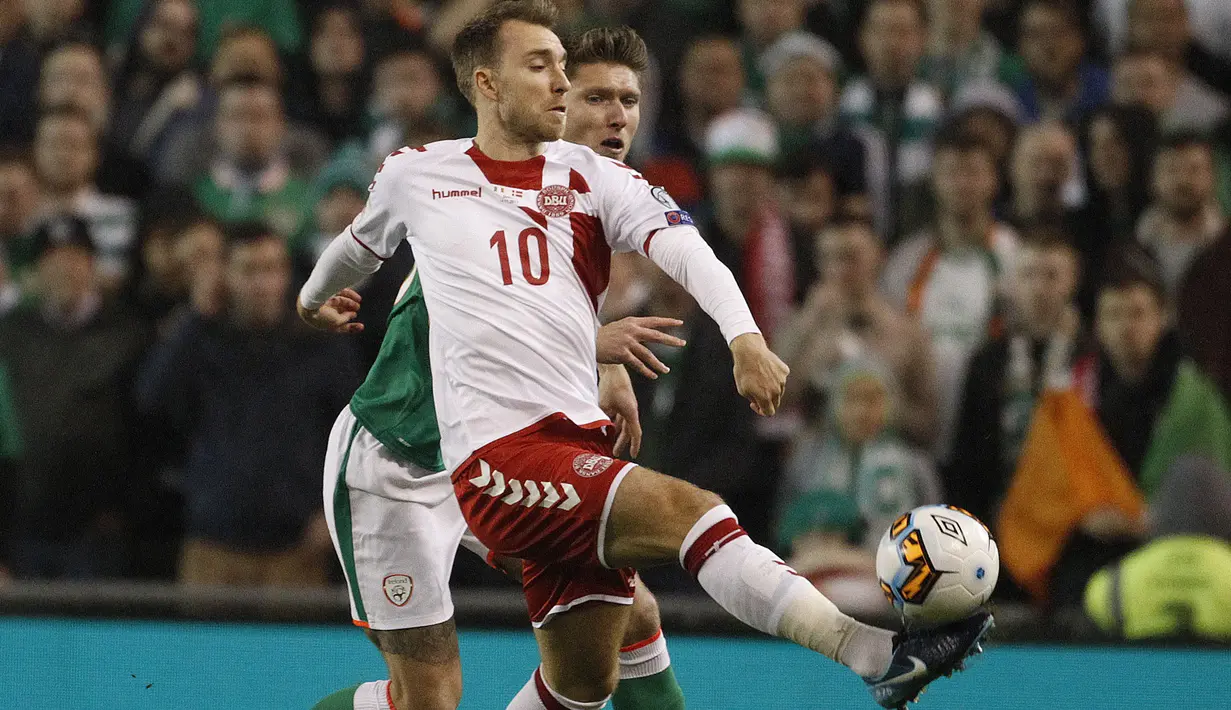 Pemain Denmark, Christian Eriksen mencoba melewati adangan pemain Irelandia, Robbie Brady pada laga leg kedua kualifikasi Piala Dunia 2018 di Aviva Stadium, Dublin, (14/11/2017). Denmark menang 5-1. (AP/Peter Morrison)