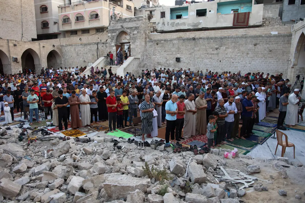 Warga Palestina melaksanakan salat Idul Adha di halaman Masjid Omari yang bersejarah di Kota Gaza, yang rusak akibat pemboman Israel. (Omar Al-Qattaa/AFP)