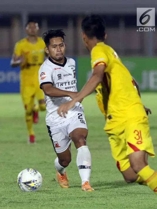 Pemain depan Madura United FC, Andik Vermansyah (tengah) mencoba melewati hadangan gelandang Bhayangkara FC, Arif Setiawan pada lanjutan Shopee Liga 1 Indonesia 2019 di Stadion Madya Gelora Bung Karno, Jakarta, Senin (5/8/2019). Laga kedua tim berakhir imbang 1-1. (Liputan6.com/Helmi Fithriansyah)