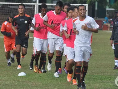 Para pemain Persija melakukan pemanasan dengan berlari bersama saat menjalani latihan di Lapangan Yon zikon 13, Jakarta, Jumat (9/1/2015).  (Liputan6.com/Miftahul Hayat) 