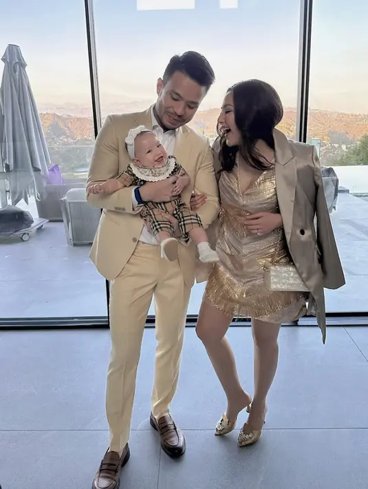 Jessica Mila terlihat glamor dengan gaun emas, sedangkan sang buah hati menggemaskan dengan baby attire dari Burberry lengkap dengan bandana yang menggemaskan. [Foto: instagram/ Jessica Mila]
