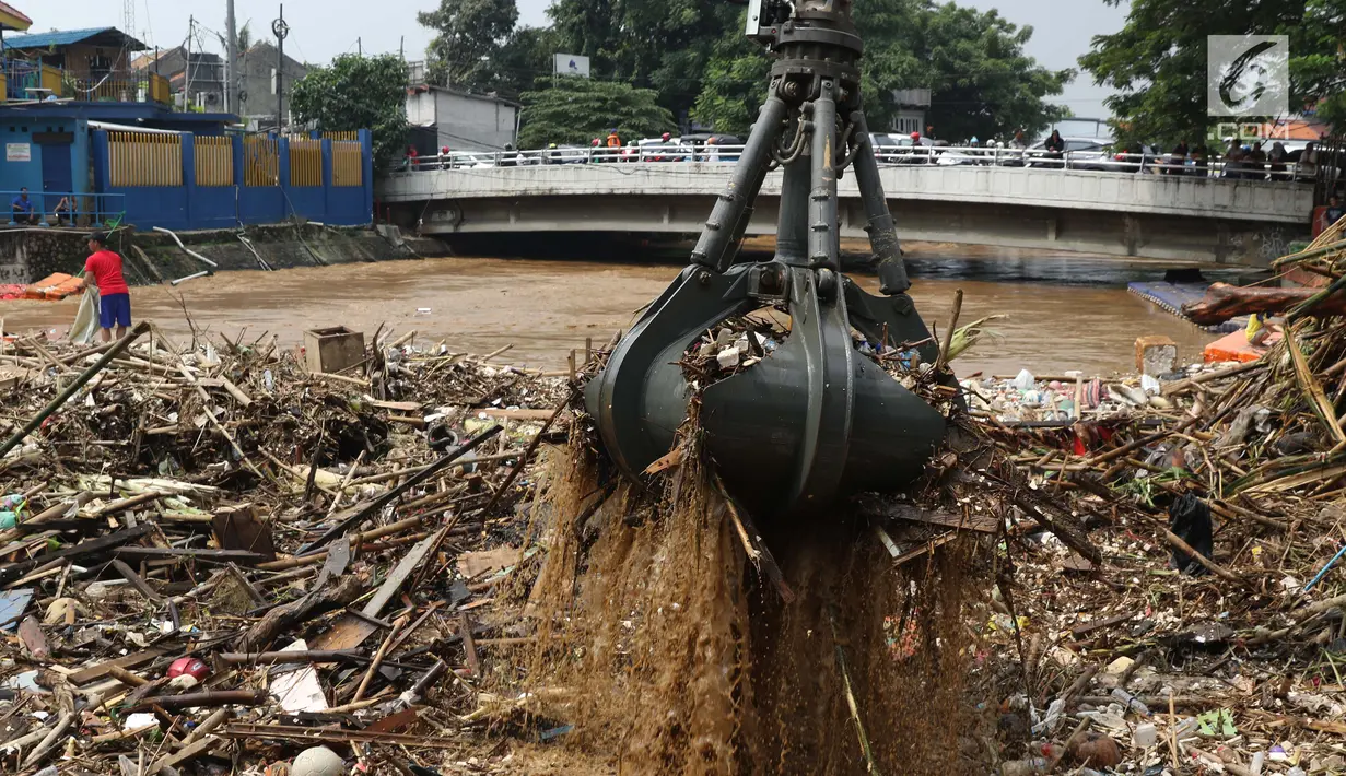 Alat berat mengangkat sampah yang menumpuk di Pintu Air Manggarai, Jakarta, Jumat (26/4). Sampah yang didominasi potongan bambu dan botol plastik kembali memenuhi Pintu Air Manggarai akibat curah hujan yang tinggi di kawasan Bogor dan sekitarnya, Kamis (25/4). (Liputan6.com/Helmi Fithriansyah)