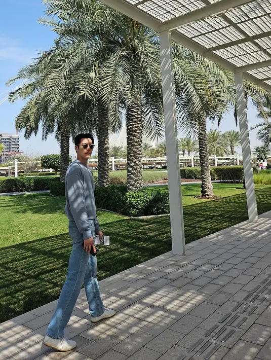 Kim Woo Bin berpose di pelataran. Dia mengenakan setelan baju lengan panjang berwarna biru yang dilengkapi dengan celana jeans. (Foto: Instagram/ ____kimwoobin)
