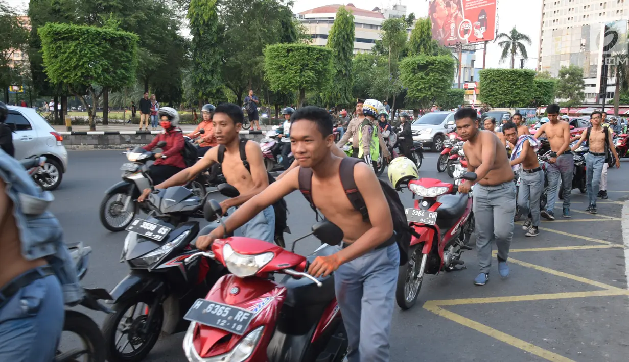Ratusan pelajar SMA mendorong sepeda motor mereka di Bundaran Simpang Lima, Semarang, Jawa Tengah, Kamis (3/5). Para siswa digelandang ke Polrestabes Semarang dengan berjalan kaki sambil menuntun motor mereka. (Liputan6.com/Gholib)