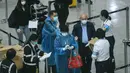 Sejumlah penumpang memakai mantel plastik untuk mengantisipasi penyebaran virus corona Covid-19 di Bandara Internasional Hong Kong, Hong Kong (19/3/2020). (AFP/Anthony Wallace)