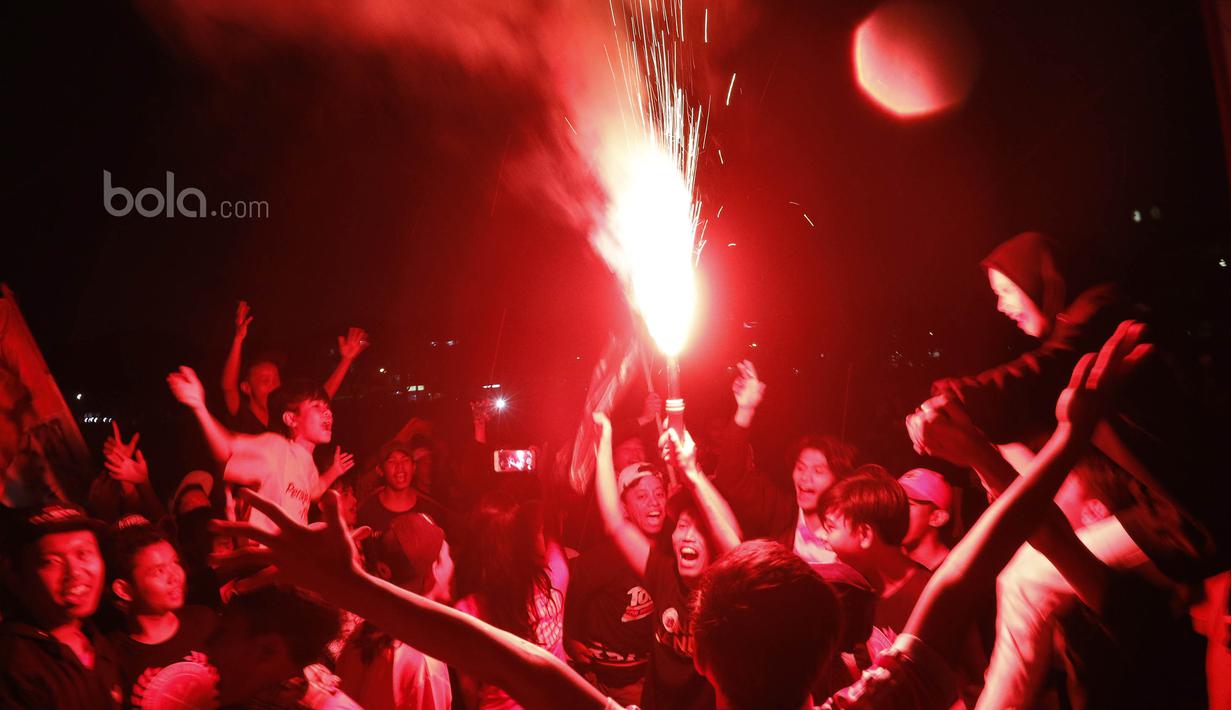 Jakmania menyalakan flare saat nonton bareng laga Persib kontra Persija di Kalideres, Jakarta, Sabtu (22/7/2017). Dilarang datang ke GBLA membuat Jakmania menggelar nobar di beberapa titik ibu kota. (Bola.com/M Iqbal Ichsan)