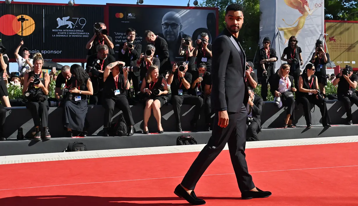 <p>Aktor Inggris Rege-Jean Page tiba untuk pemutaran film 'The Banshees of Inisherin' pada acara Venice International Film Festival ke-79 di Lido, Venesia, Italia, 5 September 2022. Aktor itu mengenakan jas hitam dan celana dengan warna senada. (Andreas SOLARO/AFP)</p>