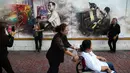 Warga berfoto di depan gambar raja Thailand Bhumibol Adulyadej di dekat Grand Palace, Bangkok, Thailand, Selasa (18/10). Setelah wafatnya raja Thailand, banyak respon positif untuk mengenang mendiang. (Reuters/Athit Perawongmetha)