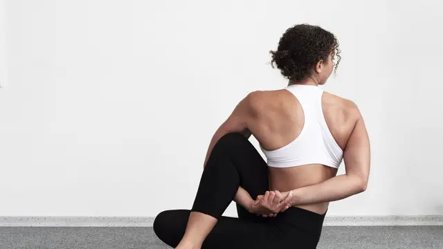 Gerakan seated back twist membantu melemaskan area punggung bagian bawah