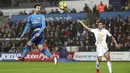 Aksi pemain Arsenal, Henrikh Mkhitaryan menyundul bola saat melawan Swansea City pada lanjutan Premier League di Liberty Stadium, Swansea, Wales, (30/1/2018). Arsenal kalah 1-3. (Nick Potts/PA via AP)