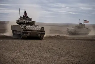 Tentara Amerika mengendarai kendaraan tempur Bradley selama latihan bersama dengan Pasukan Demokrat Suriah di pedesaan Deir Ezzor di timur laut Suriah, Rabu (8/12/2021). Puluhan tentara Amerika dan Pasukan Demokrat Suriah berpartisipasi dalam latihan bersama satu hari.  (AP Photo/Baderkhan Ahmad)