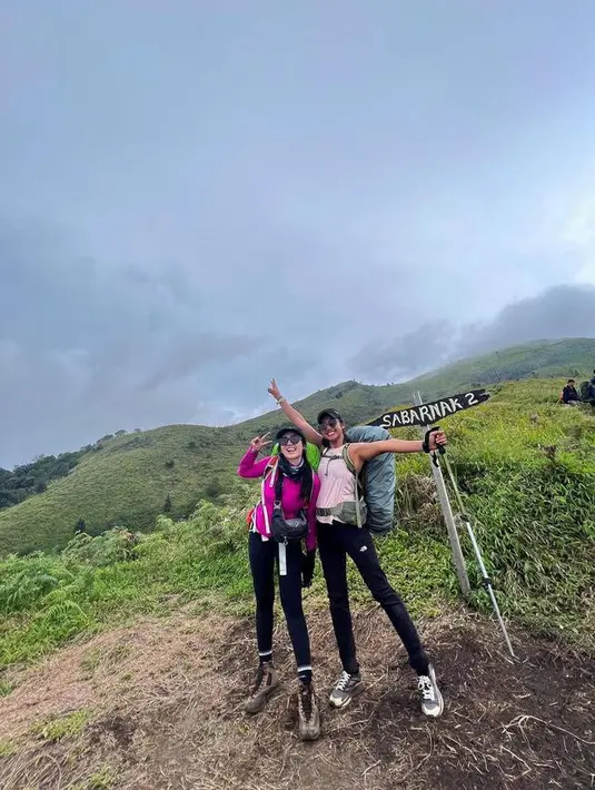 Febby Rastanty mengenakan kaca mata hitam berpose dengan temannya saat baru saja hiking ke Gunung Merbabu, Jawa Tengah. Merbabu menjadi gunung kedua yang pernah didaki oleh Febby Rastanty. Ia bahkan sudah membuat konten vlog-nya saat naik gunung lewat video di YouTube. (Instagram/febyraastanty)