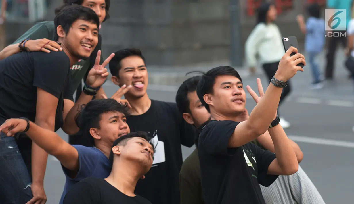 Warga berfoto bersama di sekitar panggung Jakarta Night Festival di Bundaran HI, Jakarta, Sabtu (22/6/2019). Warga terlihat antusias untuk mengikuti malam puncak HUT ke-492 Jakarta. (merdeka.com/Imam Buhori)