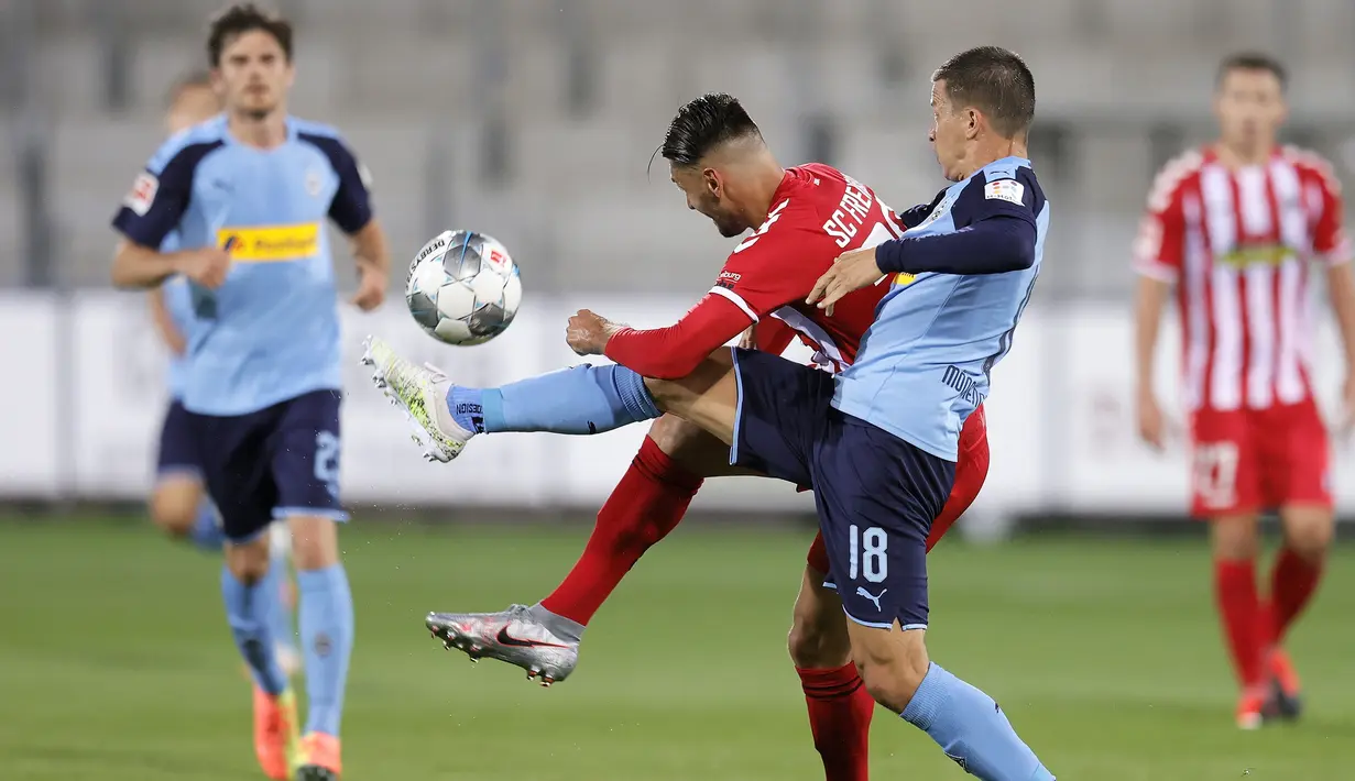 Gelandang SC Freiburg, Vincenzo Grifo, berebut bola dengan pemain Borussia Monchengladbach pada laga lanjutan Bundesliga di Freiburg, Jumat (5/6/2020) waktu setempat. Monchengladbach kalah 0-1 atas Freiburg. (AFP/Ronald Wittek/Pool)