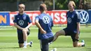 Pemain Jerman Timo Werner (kiri) dan Julian Brandt (kanan) melakukan peregangan saat sesi latihan di pusat olahraga BVSC, Budapest, Hungaria, 13 Juni 2022. Jerman akan menghadapi Italia pada pertandingan sepak bola UEFA Nations League. (Attila KISBENEDEK/AFP)