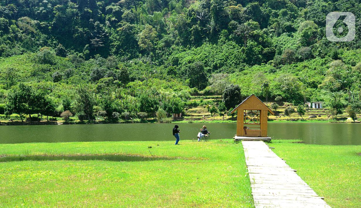 Wisatawan menikmati Situ Rawa Gede yang Instagrammable di kawasan Puncak Dua, Sukamakmur, Bogor, Jumat (6/1/2023). Meski kawasan Puncak Dua belum dikembangkan secara maksimal oleh Pemkab Bogor dan pemerintah pusat, warga seputar Jabodetabek dan Cianjur tetap antusias mengunjungi kawasan ini sebagai tempat wisata alternatif selain kawasan Puncak dan sekitarnya yang selalu didominasi kemacetan lalu lintas. (merdeka.com/Arie Basuki)