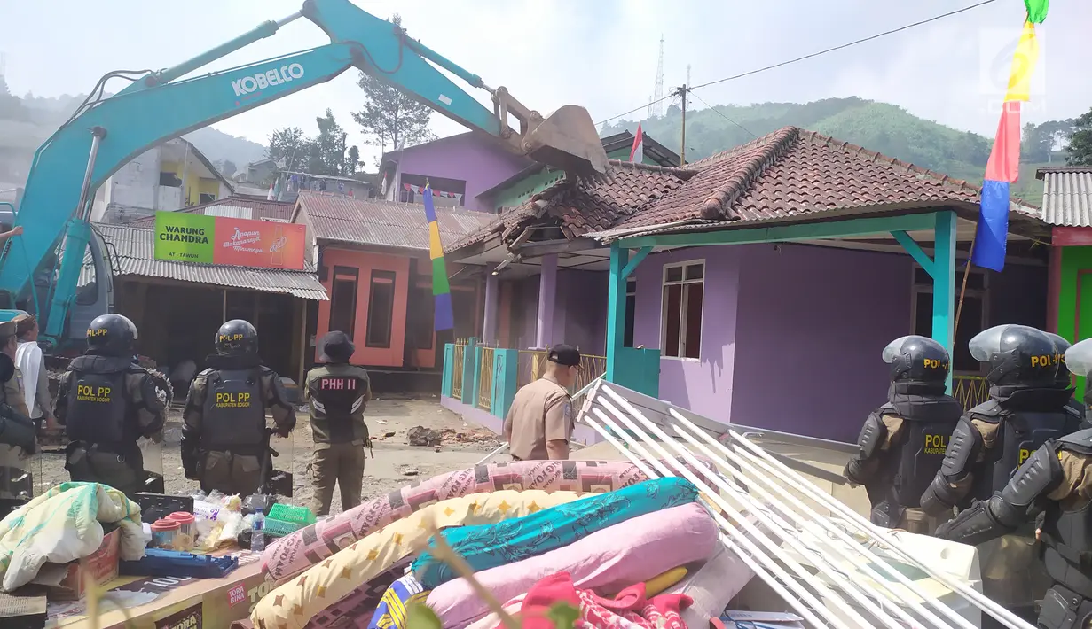 Pekerja mengoperasikan alat berat disaksikan personel gabungan saat pembongkaran bangunan di Kampung Naringgul, Kab. Bogor, Kamis (29/8/2019). Pembongkaran bangunan yang kerap digunakan sebagai penginapan jam-jaman hingga tempat mesum itu melibatkan 500 persenel gabungan. (Liputan6.com/Alby Azka)