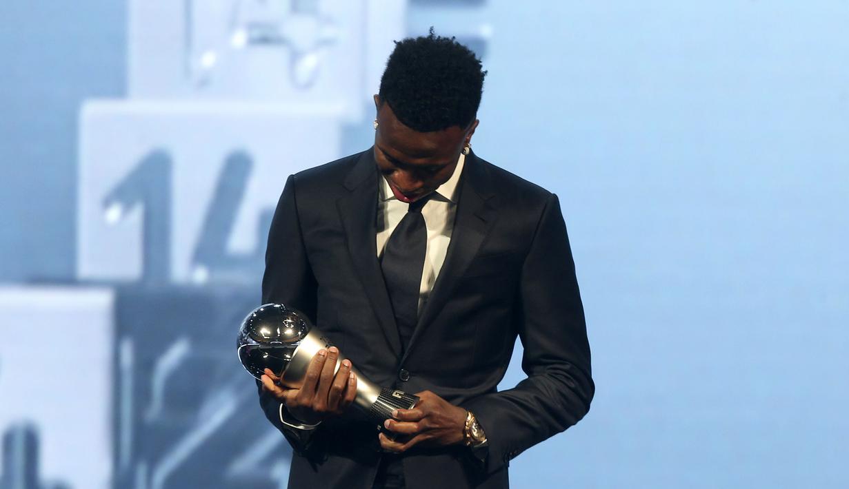 Pemain Real Madrid, Vinicius Jr memandang trofi penghargaan pemain pria terbaik FIFA 2024 dalam acara yang berlangsung di oha, Qatar pada Selasa (18/12) malam waktu setempat. (AP Photo/Hussein Sayed)