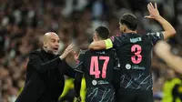 Selebrasi gelandang Manchester City, Phil Foden (tengah) bersama pelatih, Pep Guardiola setelah mencetak gol penyeimbang 2-2 ke gawang Real Madrid pada laga leg pertama babak perempatfinal Liga Champions 2023/2024 di Santiago Bernabeu Stadium, Selasa (9/4/2024) malam. (AP Photo/Manu Fernandez)