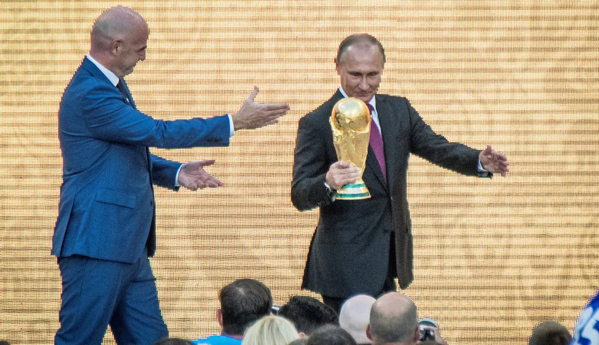 Presiden Rusia Vladimir Putin memegang trofi Piala Dunia dalam pembukaan upacara  "FIFA World Cup Trophy Tour" di stadion Luzhniki di Moskow (9/9). Piala Dunia 2018 adalah Piala Dunia FIFA ke-21. (AFP Photo/Mladen Antonov) 