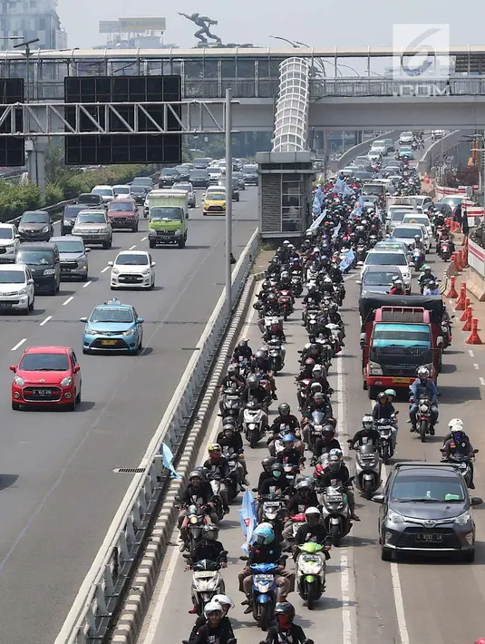 Konvoi buruh menggunakan sepeda motor melintas di Jalan Gatot Soebroto, Jakarta, Selasa (1/5). Ribuan buruh dari berbagai elemen memperingati perayaan Hari Buruh untuk menyampaikan aspirasi di sejumlah titik di Ibukota. (Liputan6.com/Immanuel Antonius)
