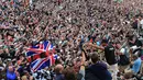 Pembalap Formula 1, Lewis Hamilton merayakan kemenangan bersama pengemarnya usai berlaga di Grand Prix Formula 1 Silverstone di Inggris, (5/7/2015). Hamilton berhasil finish di urutan pertama dengan waktu 1 jam 31 menit 27,729 detik. (Reuters/Stringer)