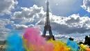 Bermacam serbuk warna bertebaran saat acara Color Run 2017 di depan Menara Eiffel, Paris, Minggu (16/4). Lomba lari sepanjang 5 km tanpa hadiah itu diikuti ribuan peserta. (AFP PHOTO / CHRISTOPHE ARCHAMBAULT)