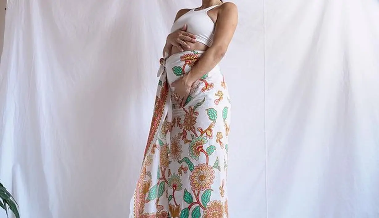 Di potret lainnya, Jennifer menunjukkan pesona keibuannya menggunakan kain. Kain batik bermotif bunga ini hanya dililit dan dipadukan dengan crop top berwarna putih. (instagram/jenniferbachdim)