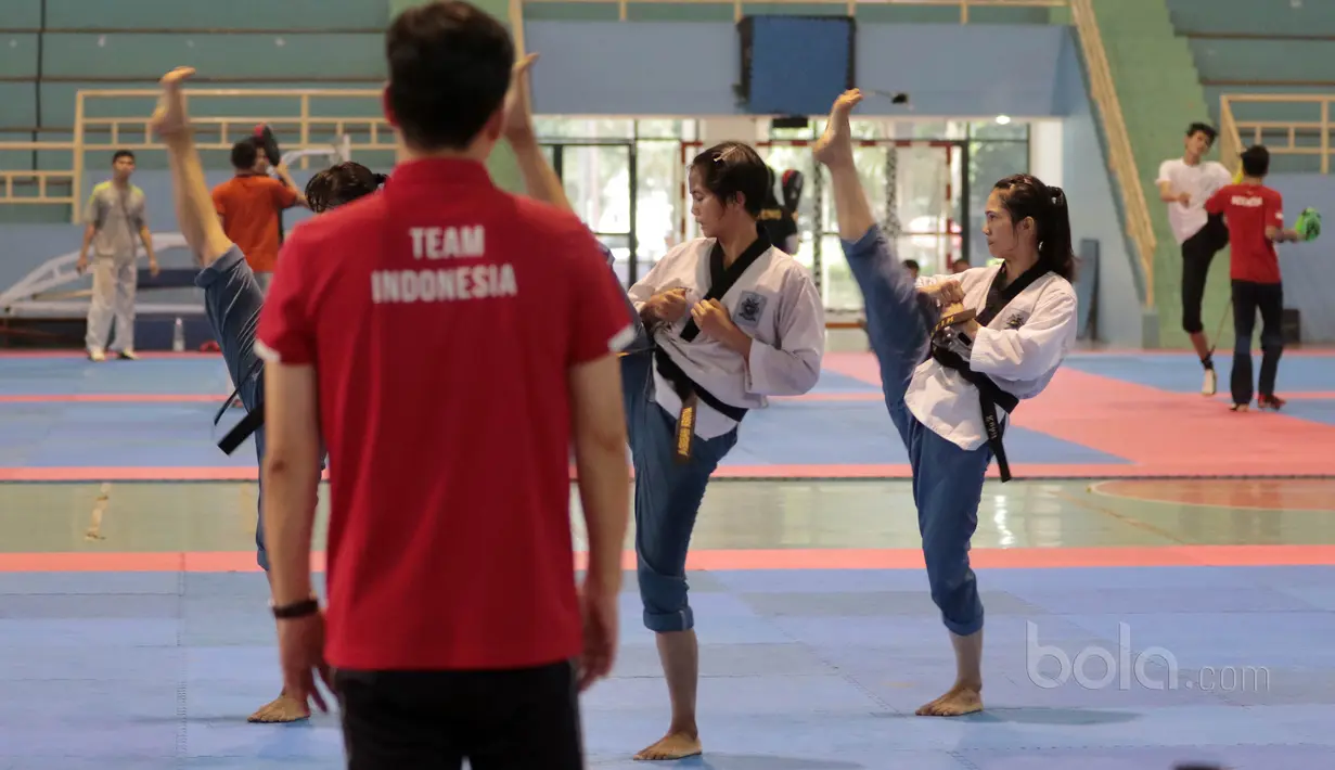 Aksi Tim putri Taekwondo Indonesia yang ikut kategori Poomsae berlatih gerakan dasar dipandu pelatih asal Korea di GOR Popki, Cibubur (13/7/2017). (Bola.com/Nicklas Hanoatubun)