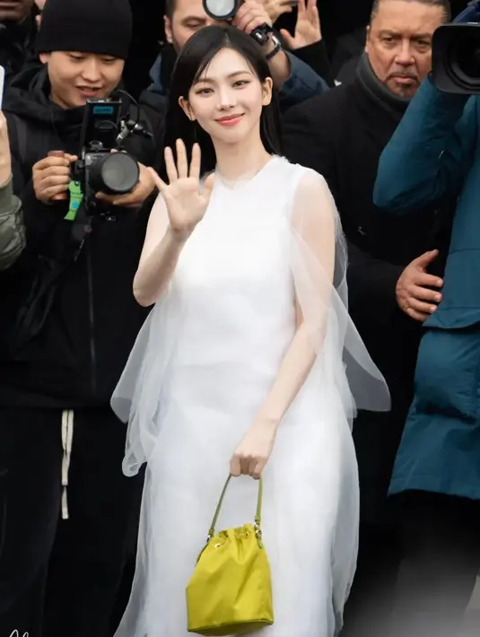 Ia menjinjing mini bag Prada berwarna kuning yang terlihat stand out pada penampilannya. Ditutup dengan heels hitam yang terliaht lebih elegan [@aespasyujimin]